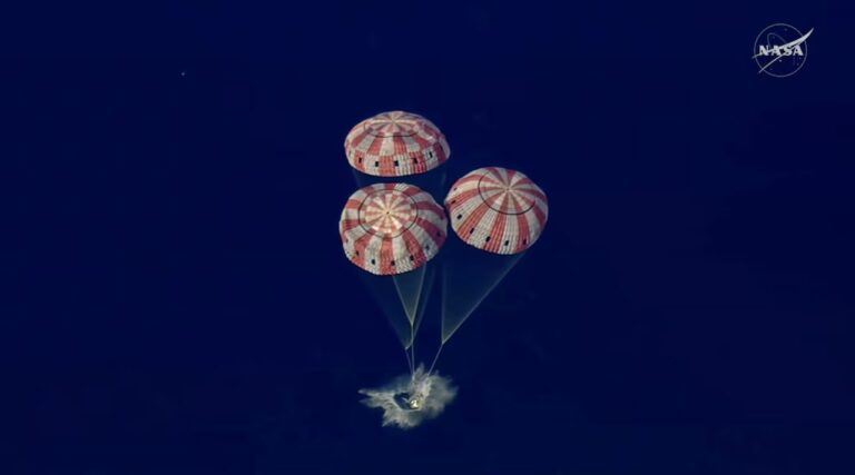 La cápsula espacial Orion flotando en el océano Pacífico tras su amerizaje, con equipos de recuperación en la zona.