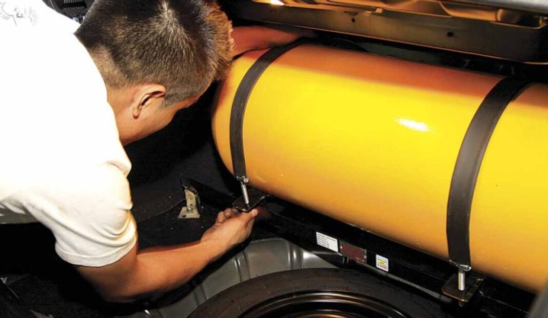 Taller especializado instalando equipo de Gas Natural Comprimido (GNC) en un automóvil.