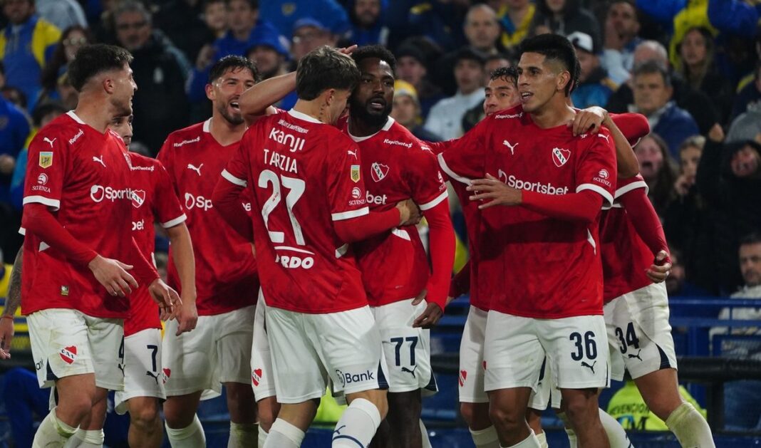 Escudos de Boca Juniors e Independiente enfrentados, representando el clásico del fútbol argentino.