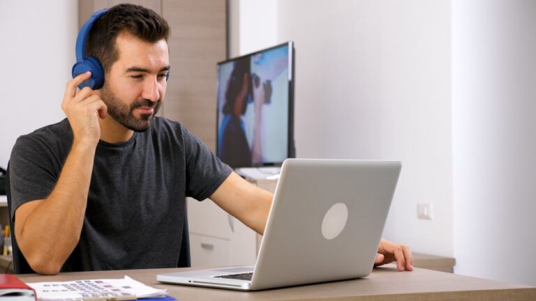 Profesional trabajando en una laptop en un entorno de oficina moderna, representando el sector de la economía del conocimiento.