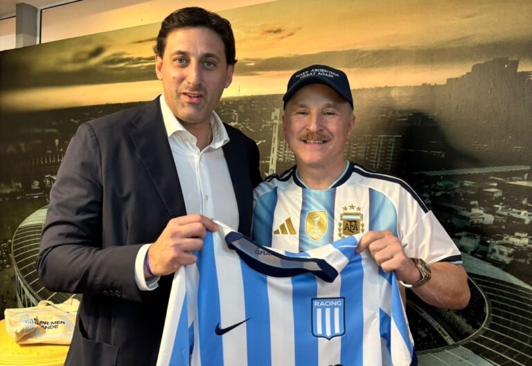 El embajador Peter Lamelas y Diego Milito posan con la camiseta de Racing Club.
