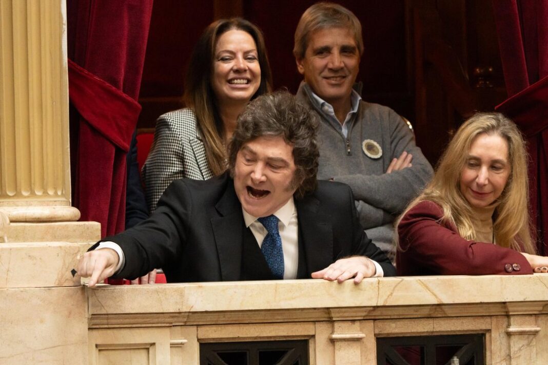 Javier Milei sonriendo frente a una pantalla con la palabra Riesgo País