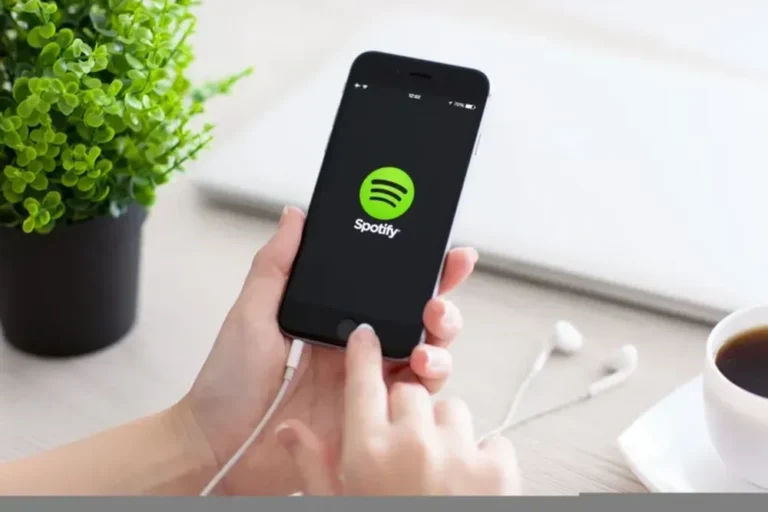 Logotipos de Spotify y Universal Music Group sobre fondo musical