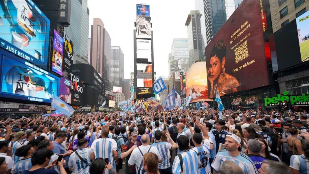 Hinchas argentinos en Times Square con banderas celestes y blancas durante el banderazo previo a la final del Mundial