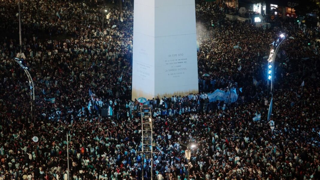 Multitud de personas con banderas argentinas en el Obelisco celebrando la victoria de la Selección