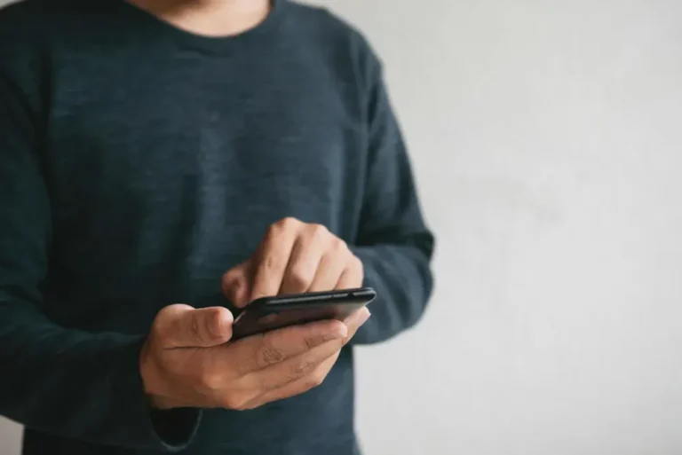 Persona mirando su teléfono móvil con expresión de preocupación