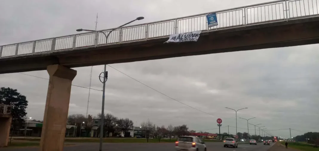 Bandera con la leyenda Las Malvinas son argentinas en el puente peatonal de Junín