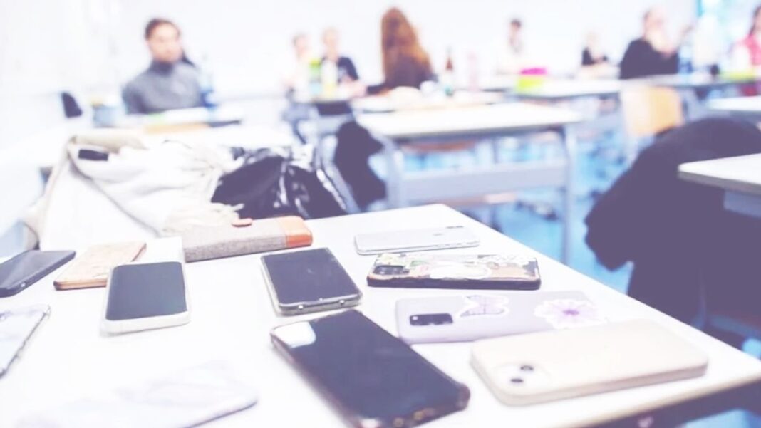 Estudiantes de secundaria en un aula con celulares guardados