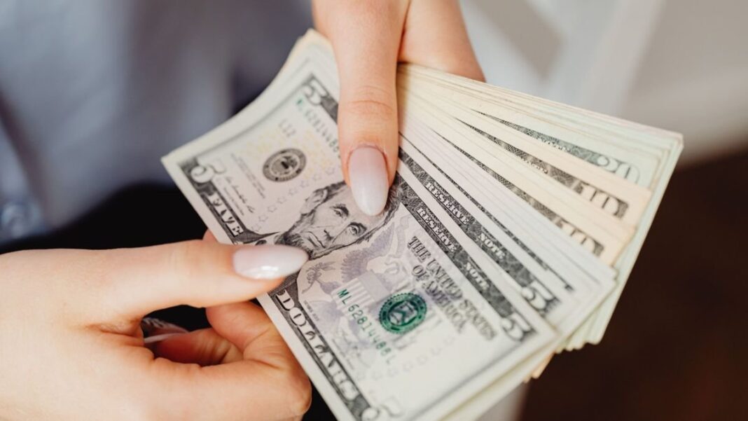 Personas en una casa de cambio con billetes de dólar